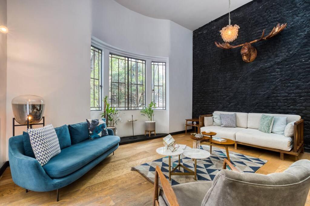 sala de estar con sofá azul y sillas en Unique Roma Apartments S51 By MrW, en Ciudad de México