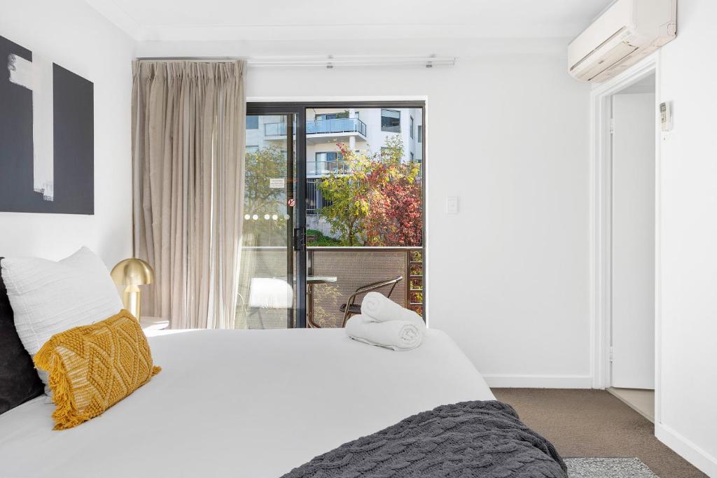 a bedroom with a large white bed and a window at Mounts Bay Charm 1br Urban Escape in Perth