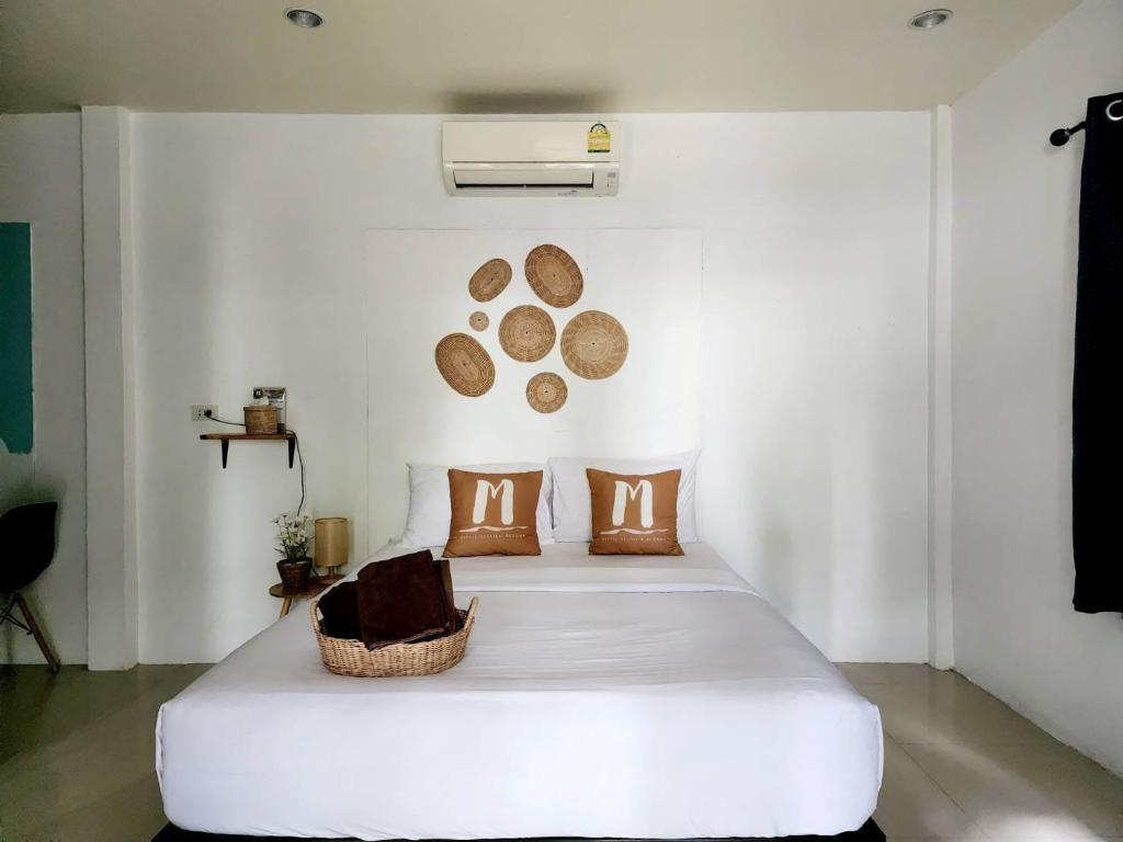 1 dormitorio con 1 cama blanca grande con almohadas marrones en Minnie Seaview Resort, en Ko Samed