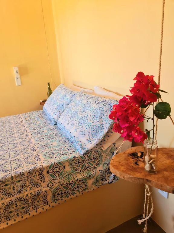 a bedroom with a bed and a table with flowers at Casa Cariri- Preá in Prea