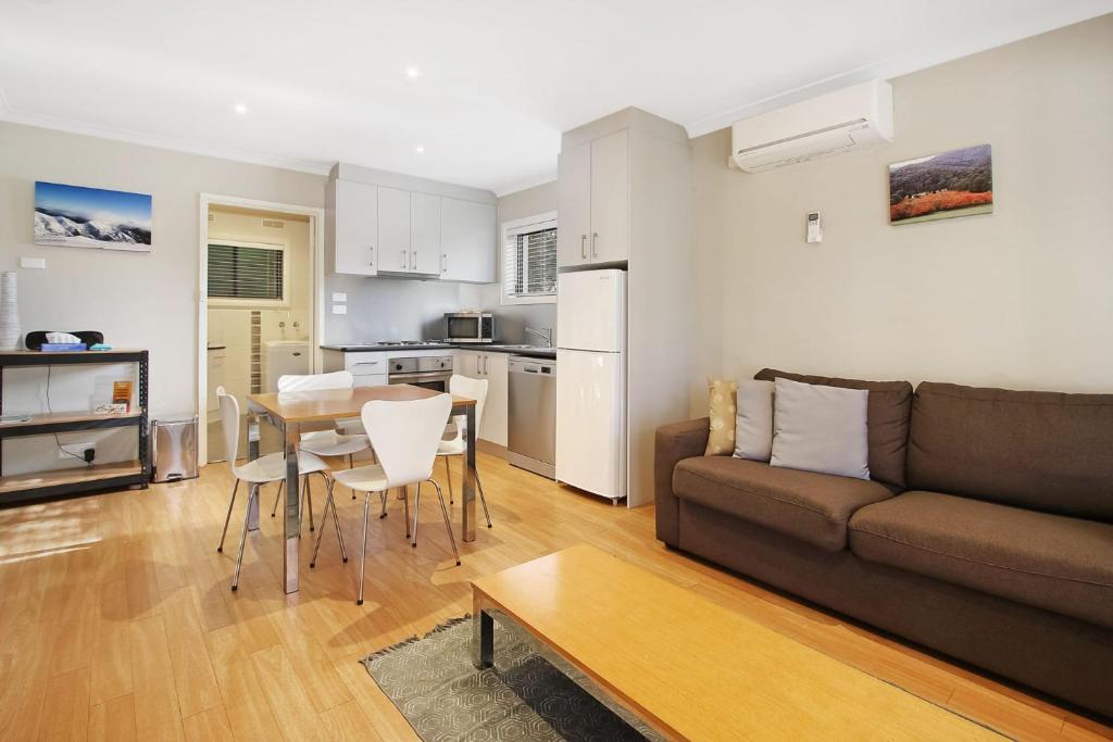 a living room with a couch and a table at Grevillea Gardens Unit 8 in Bright