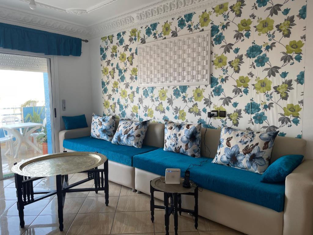 a living room with a blue couch and a table at Grand appart avec vue sur mer in Oued Laou