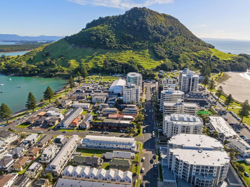 マウント・マウンガヌイにあるThe Iconic Kiwi Bach, Full Site Downtown Mountの山を背景とした市街の空中風景