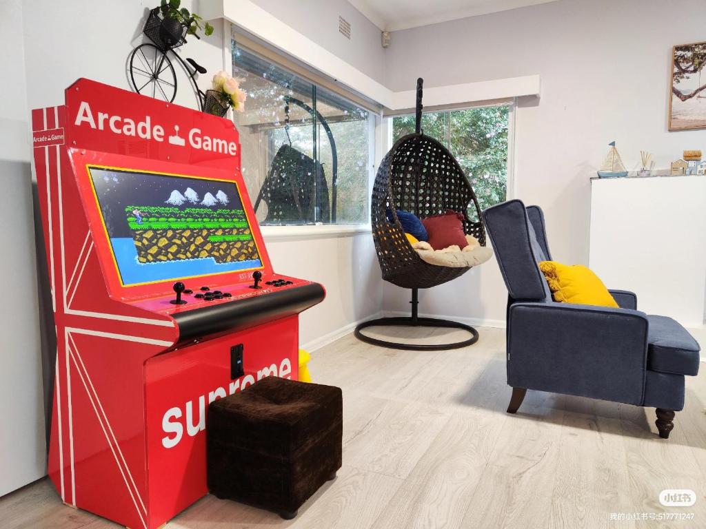 una habitación con un juego de arcade y una silla en Lake View House entire house, en Gosford