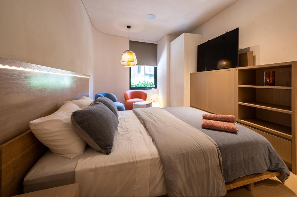 a bedroom with a large bed and a tv at Paragon in Sydney