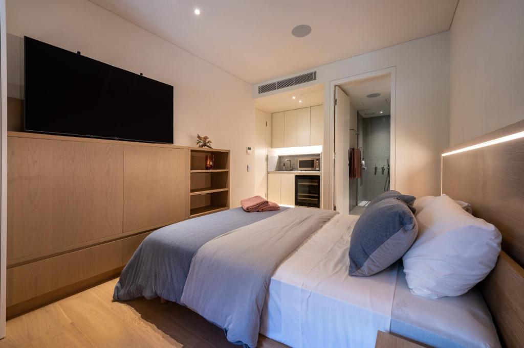 a bedroom with a large bed with a flat screen tv at Paragon in Sydney
