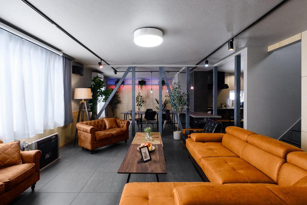 a living room with orange couches and a table at The Landmark in Furano