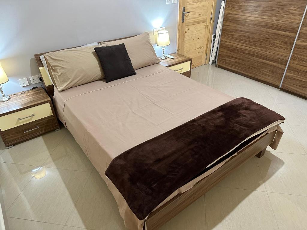 duże łóżko w sypialni z 2 stolikami nocnymi w obiekcie Ewa Apt - 3-Bedrooms Apt near Sliema - St Julians Seafront w Gżirze