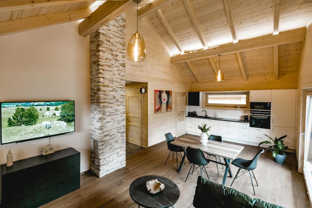 eine Küche und ein Wohnzimmer mit einem Tisch und Stühlen in der Unterkunft Chalet 49 Nesselgraben - Ferienwohnungen aus Holz in Koppl