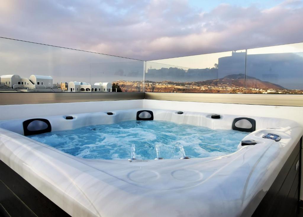 a jacuzzi tub in a room with a view at Alafropetra Luxury Suites in Akrotiri