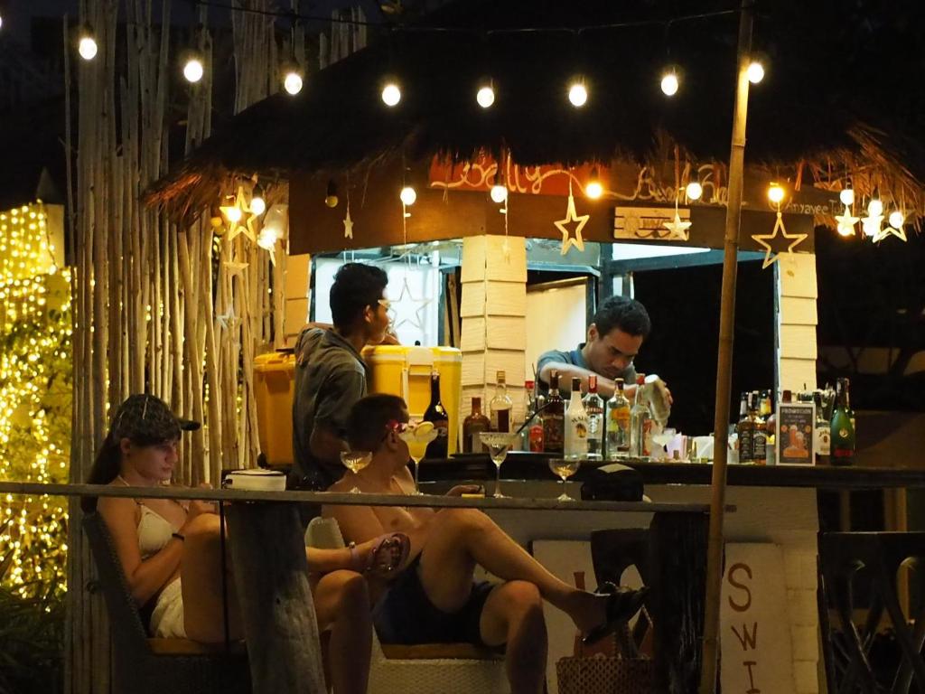 a group of people sitting at a bar at night at Anyavee Tubkaek Beach Resort in Tab Kaek Beach