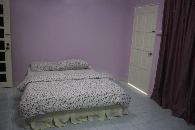 ein Schlafzimmer mit einem Bett und einer weißen Tür in der Unterkunft Wafi Guesthouse in Kuala Terengganu