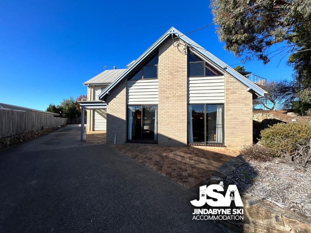 a house with a driveway in front of it at Cedar Haven in Jindabyne