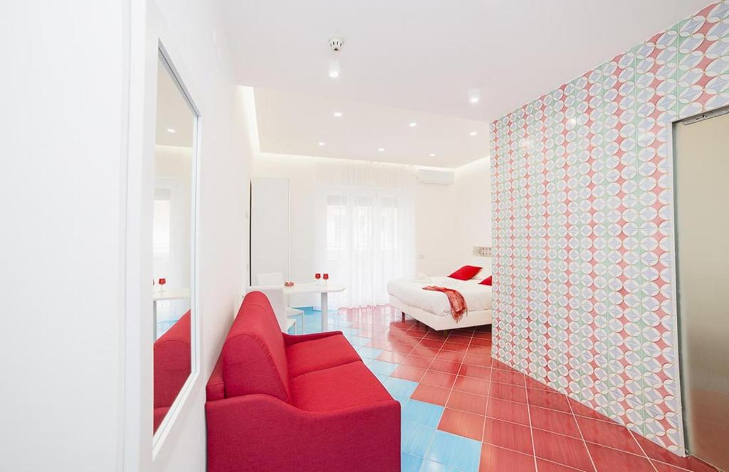 un soggiorno con un divano rosso e un letto di Hotel De Rosa a Maiori