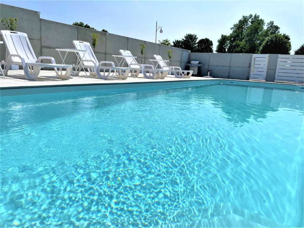 a group of chairs and a swimming pool at Apartament AQUA MAZURY in Ełk