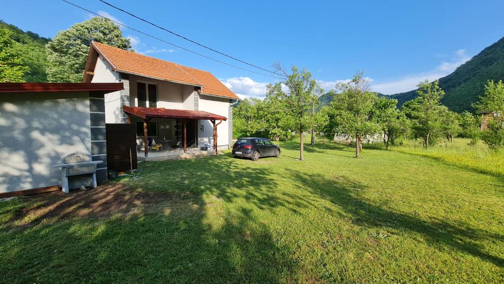 una casa con un coche aparcado delante de un patio en Vila MM Boračko jezero, en Konjic