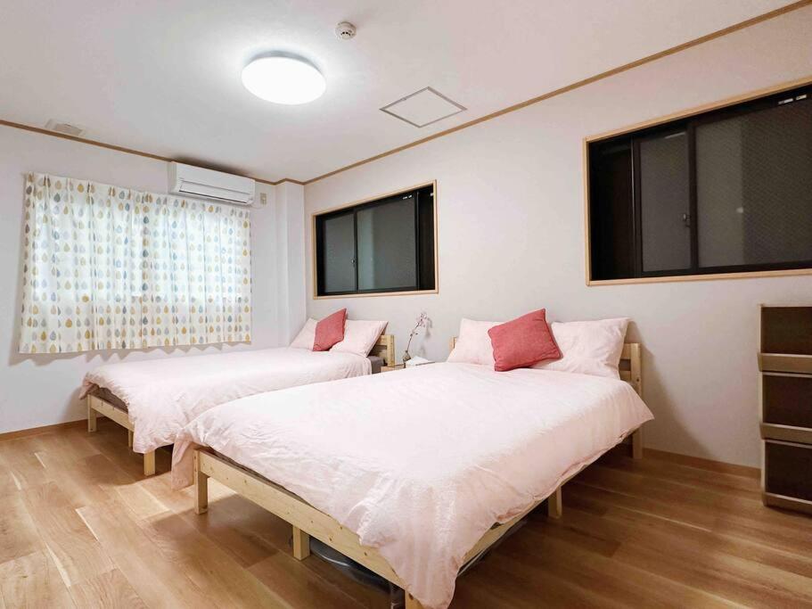 a bedroom with two beds and a large window at COZY ROOM 三丁目〜難波日本橋駅奈良駅直通/6人まで/商店街近く～60㎡快適空間～ in Osaka