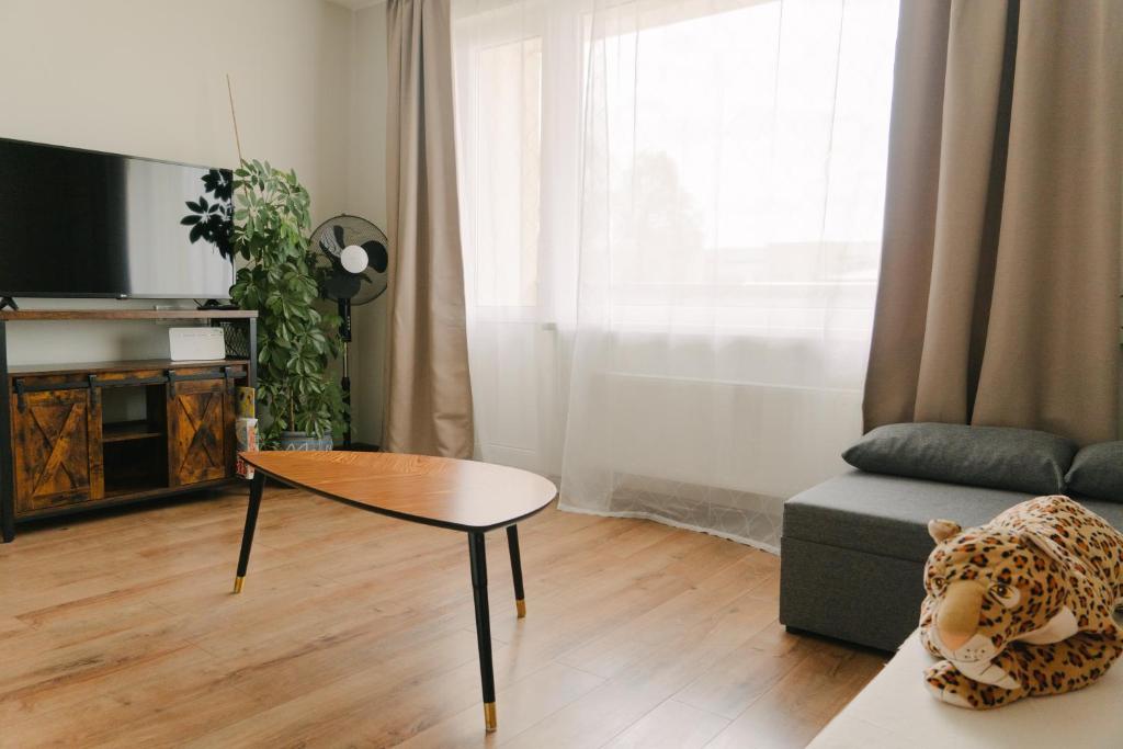 uma sala de estar com uma mesa e um sofá em Warm & Cozy Apartment with balcony in Valmiera em Valmiera