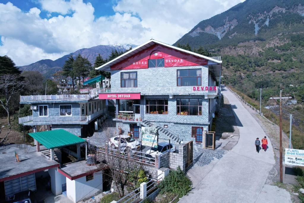 达兰萨拉HOTEL DEVDAR RESORT的山边的一座建筑