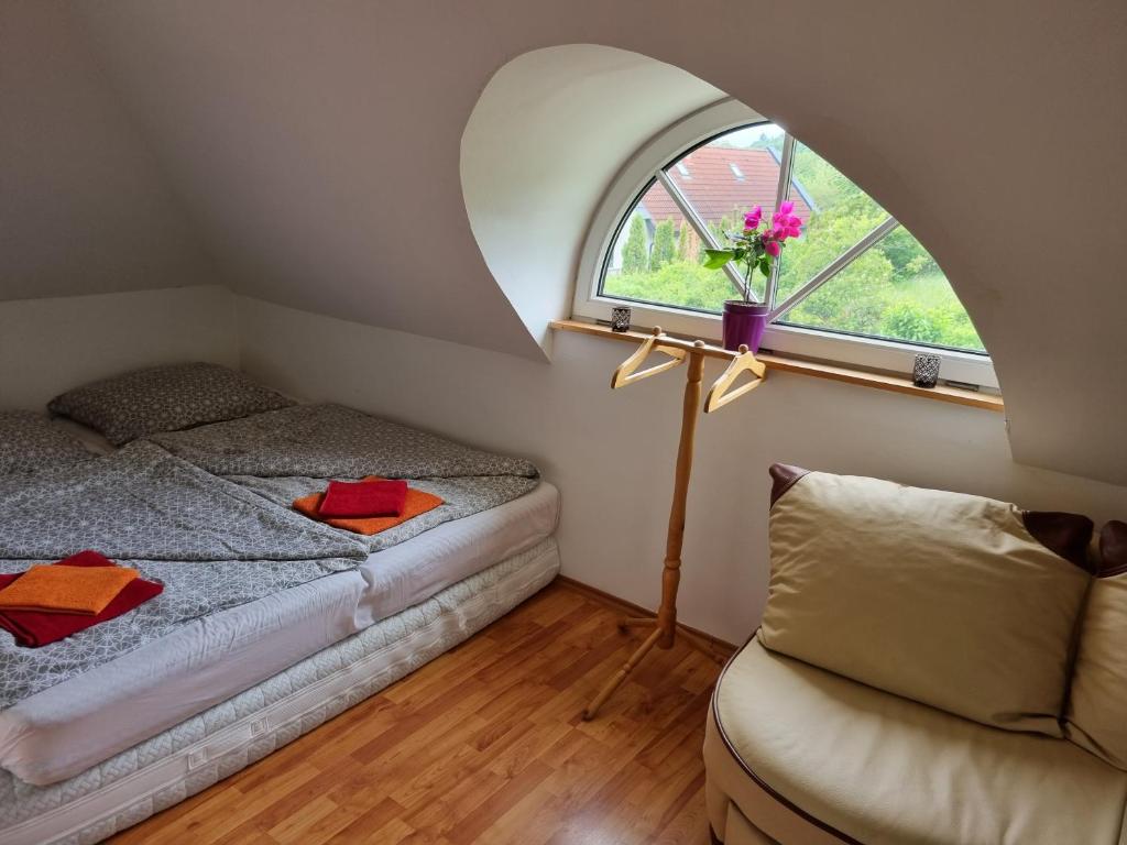 a bedroom with a bed and an arched window at Jurta Hotel Balatongyörök in Balatongyörök