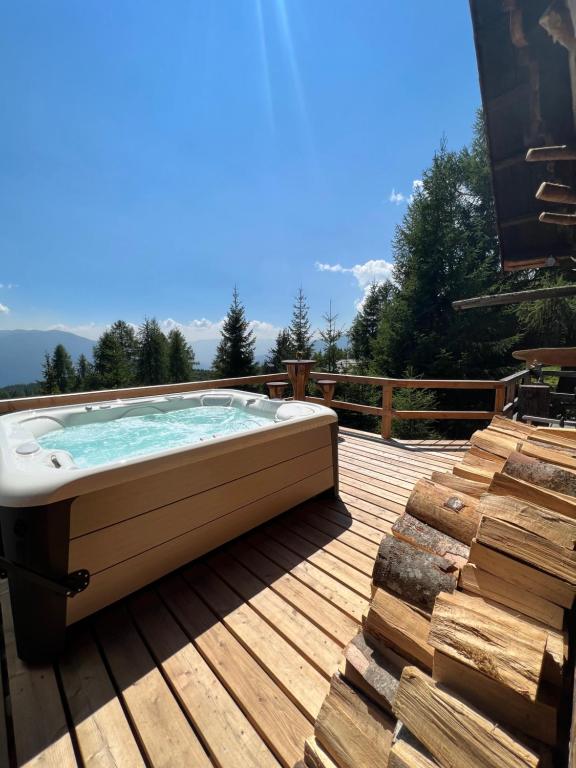 a hot tub on a deck with a view of the mountains at Almhütte Kärnten in Maltaberg