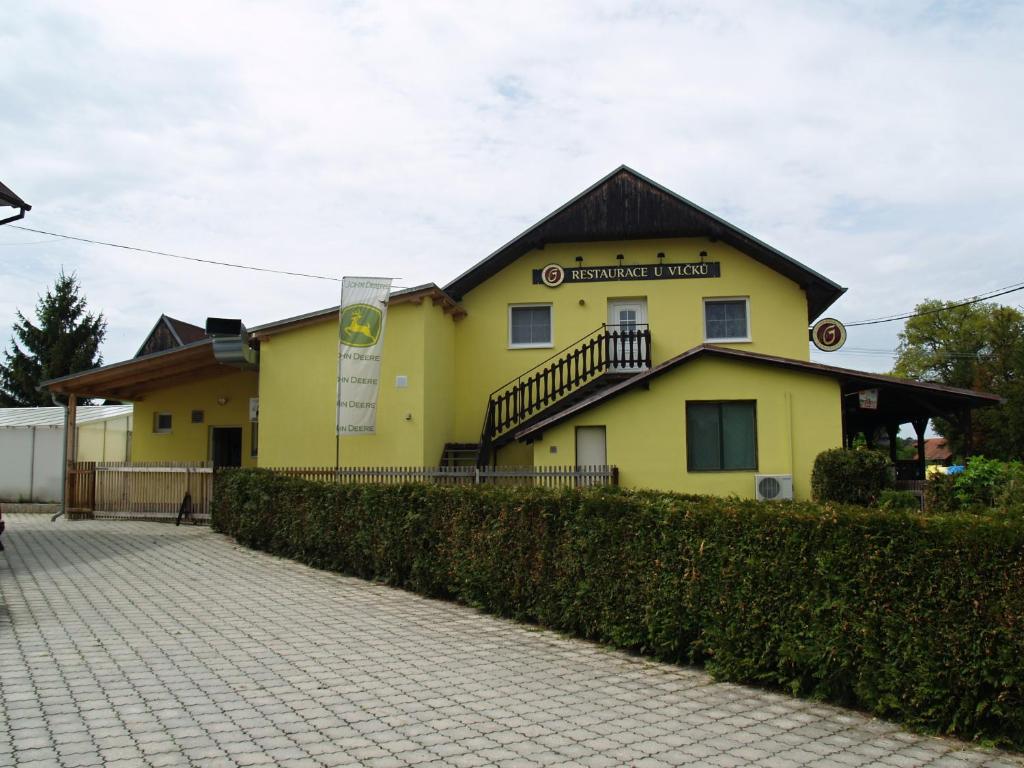 a yellow building with a fence in front of it at Pension u Vlčků in Hracholusky