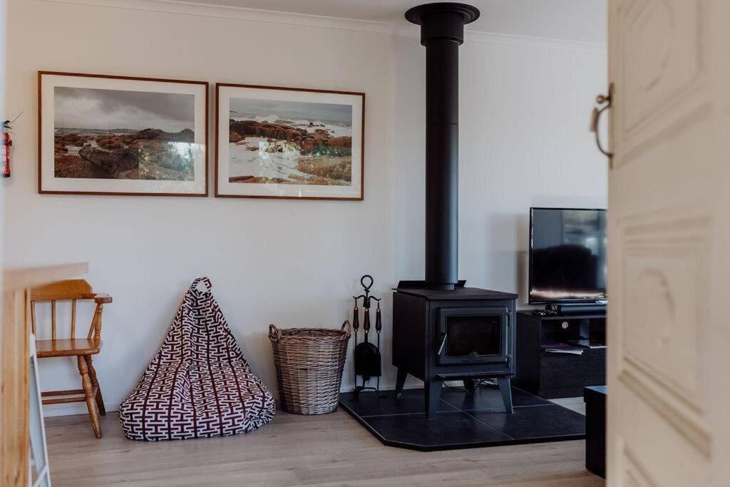 a living room with a stove and a christmas tree at Cedar House ~ Family Fun! in Bicheno