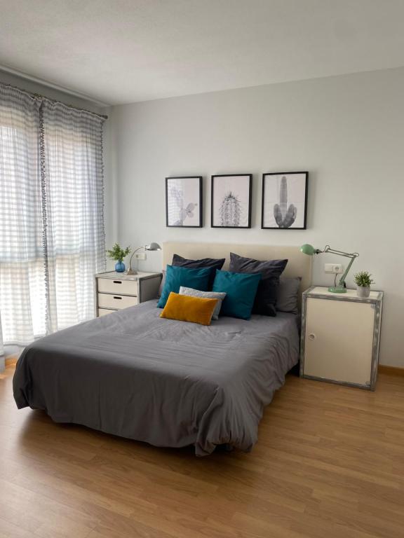 a bedroom with a large bed with blue and yellow pillows at Habitación en casa de Mikel in Olite