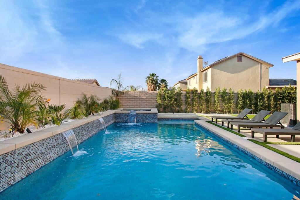 uma piscina com duas cadeiras e uma fonte em Modern Luxury Home w/ Private Pool & Spa 2.0 em Indio