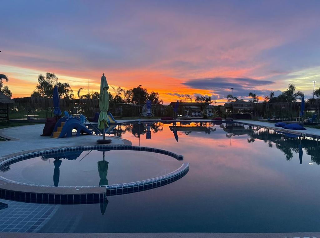 uma piscina vazia com um pôr-do-sol ao fundo em BKL Happy World 