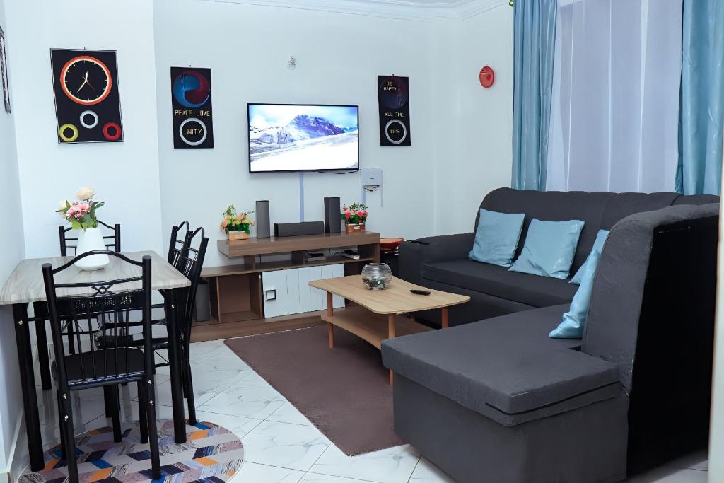 - un salon avec un canapé et une table dans l'établissement Bamburi 2BR Apartment, à Mombasa