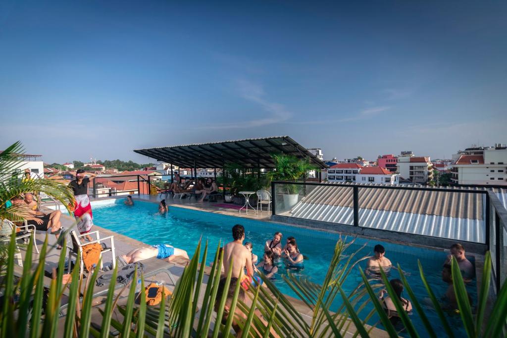 a group of people swimming in a swimming pool at Onederz Siem Reap in Siem Reap