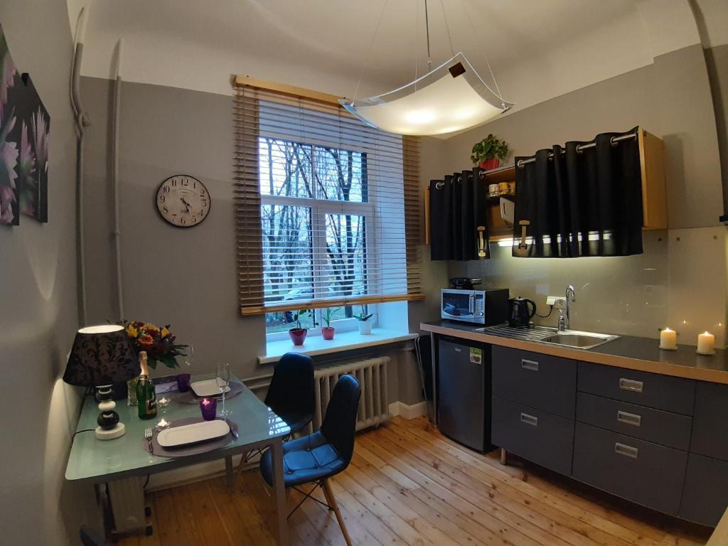 cocina con mesa, sillas y ventana en Eksporta 10, LUX en Riga