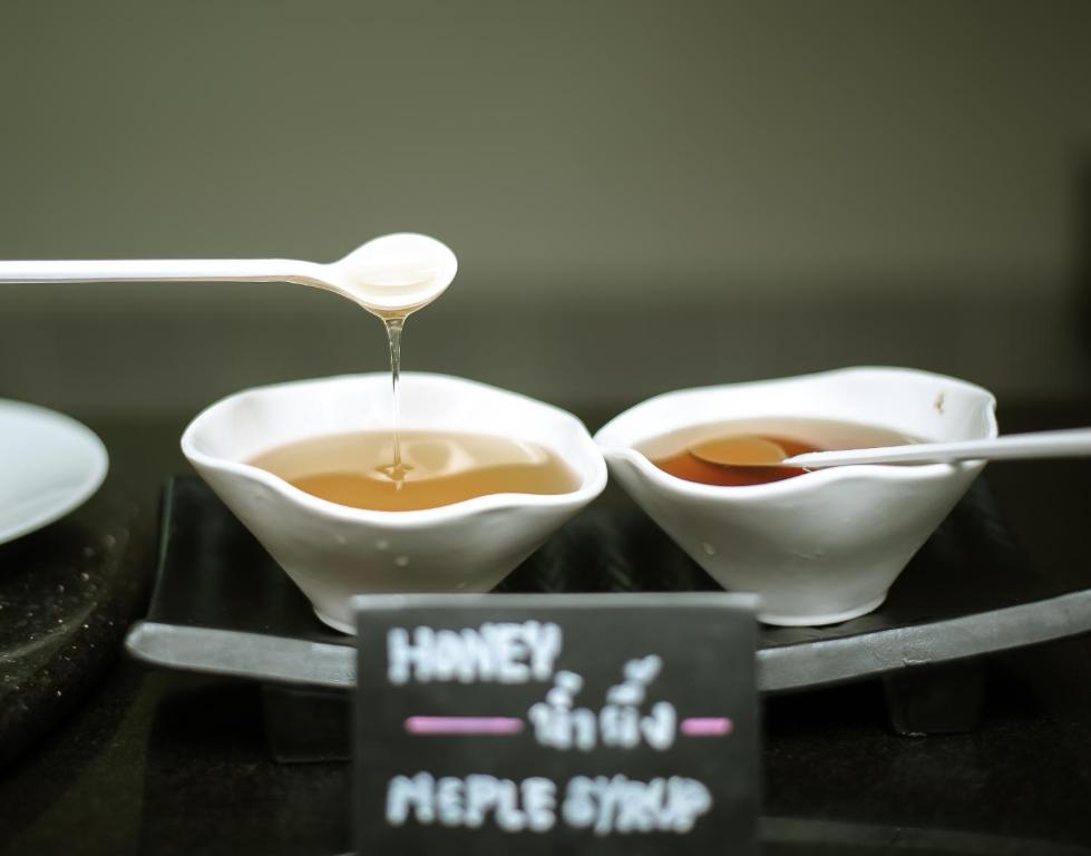 two bowls of coffee with a spoon on a tray at Anyavee Tubkaek Beach Resort in Tab Kaek Beach