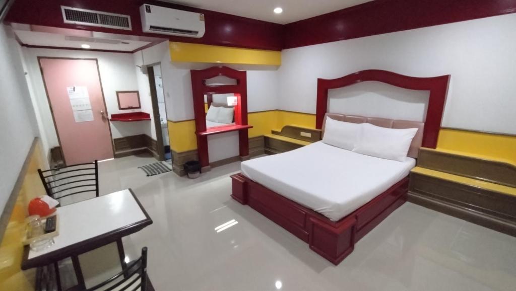 1 dormitorio con cama, mesa y escritorio en MP Inn, en Saraburi