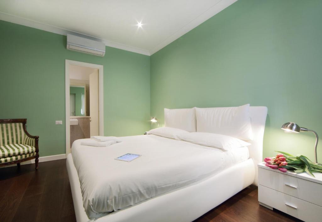 1 dormitorio con 1 cama blanca y 1 silla en The One Prati Rooms en Roma