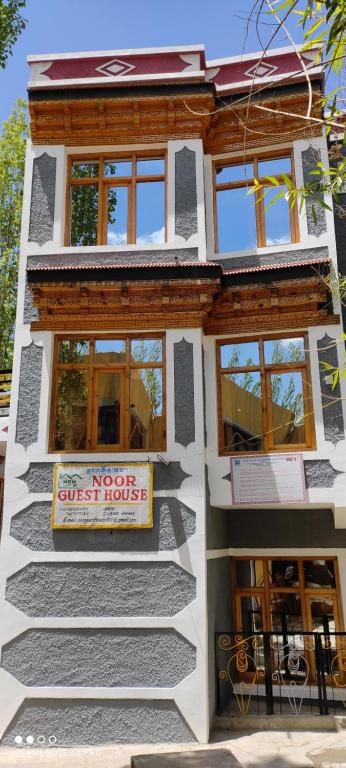 a house with a sign on the side of it at Noor Guest House in Leh