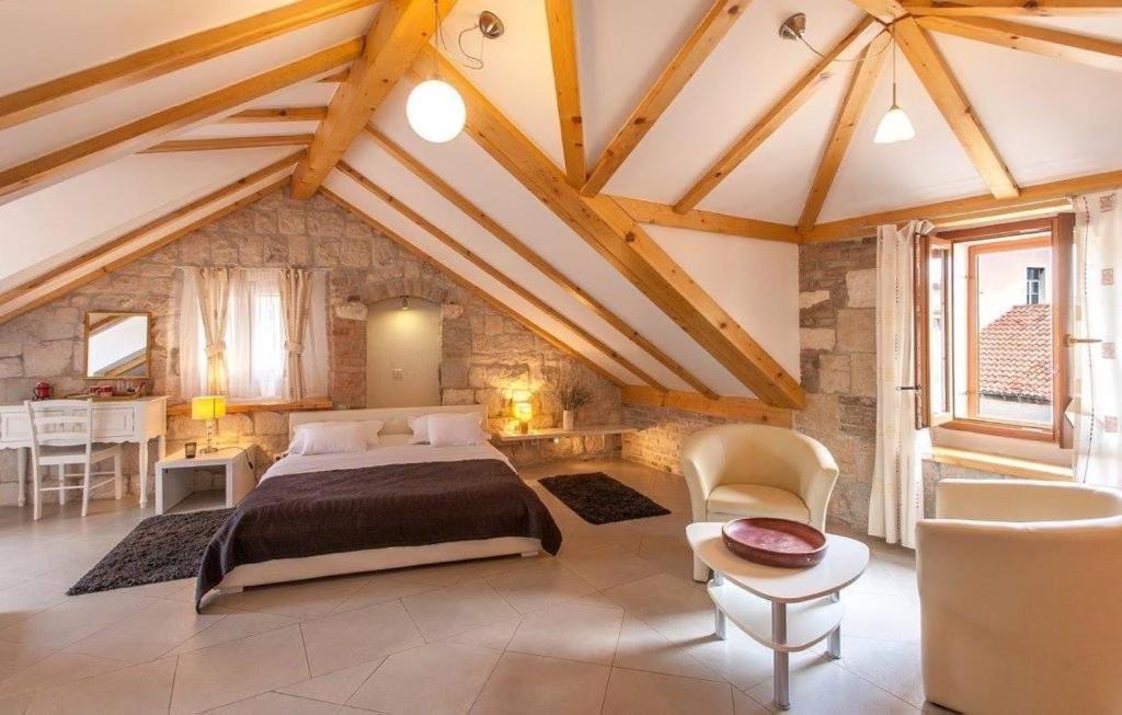 um quarto com uma cama grande num quarto com tectos em madeira em Vanjaka bed and breakfast em Trogir