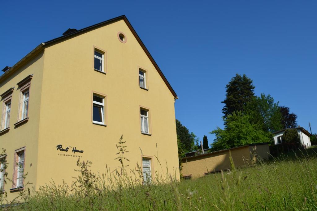 un edificio amarillo en lo alto de un campo de hierba en Ferienwohnung Eppendorf, en Eppendorf