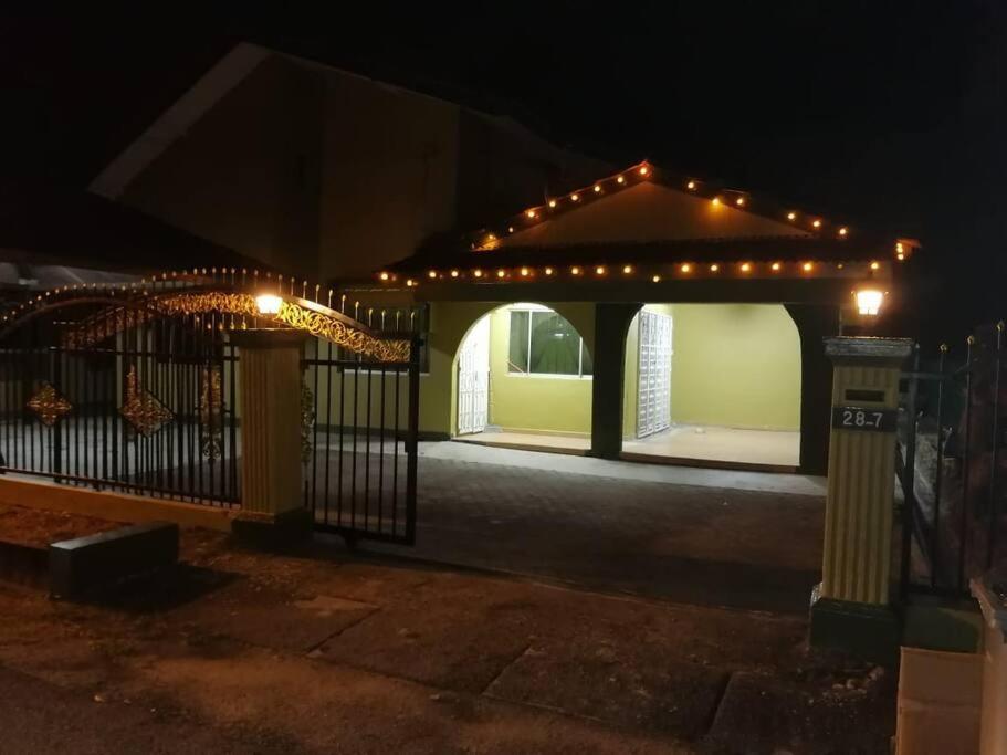 um gazebo com luzes e um portão à noite em Hajjah Homestay Tg Agas Muar em Muar