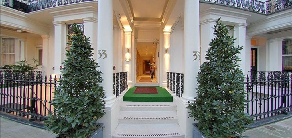 a white house with two christmas trees on the stairs at The Beaufort in London
