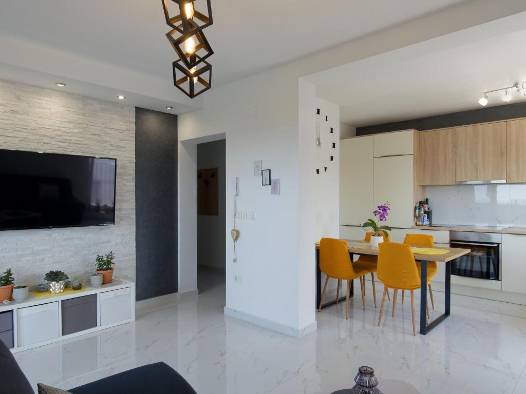 a kitchen and dining room with a table and yellow chairs at Apartment Harmony in Umag