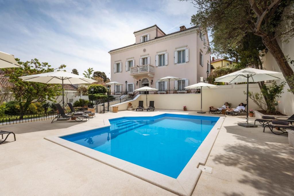 uma villa com piscina em frente a uma casa em Villa Cassia em Mali Lošinj