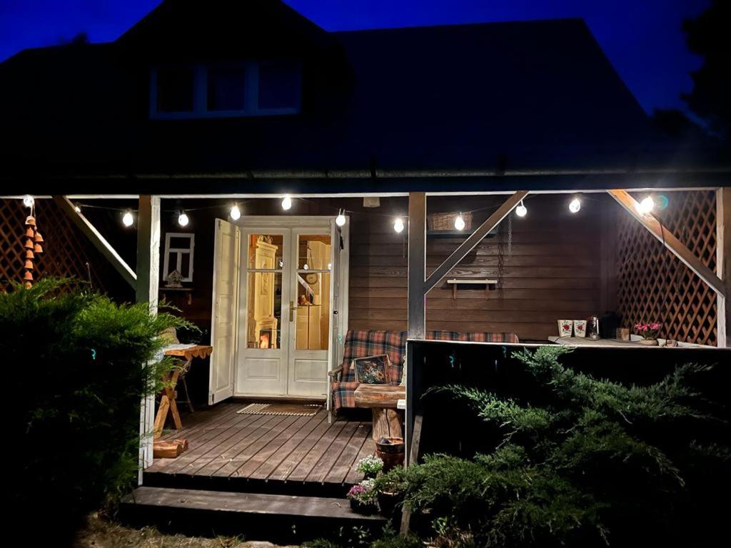 a house with a porch at night with lights at Domek Radość in Cieksyn