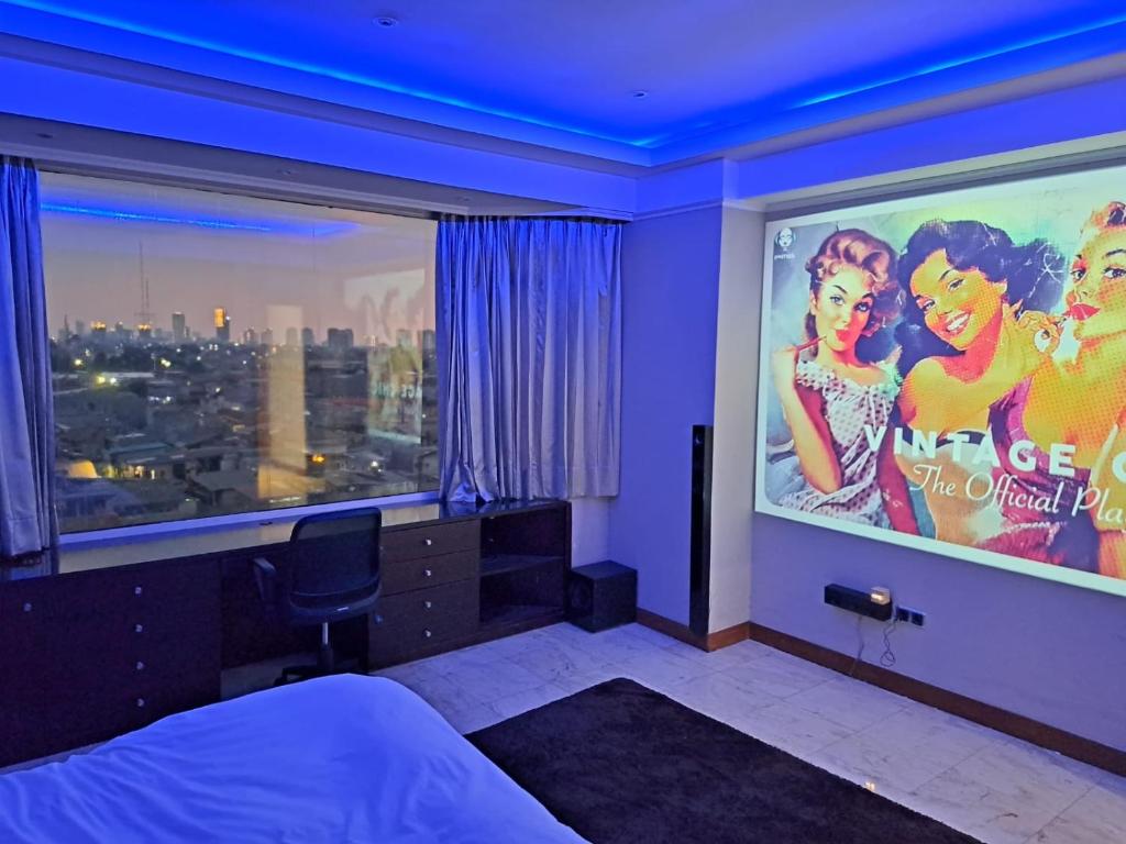 1 dormitorio con un gran cartel de cine en la pared en Slipi Apartment 2BR, en Yakarta