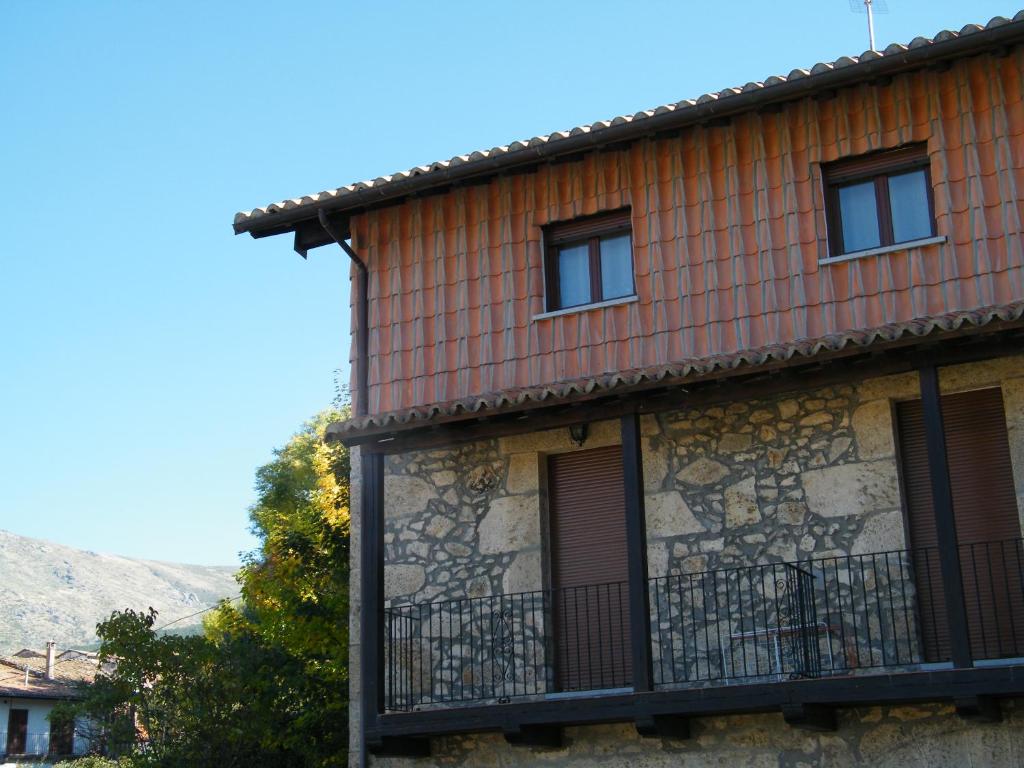 un bâtiment avec une clôture sur son côté dans l'établissement Apartamento Puerta del Sol de 1 habitación, à Candelario