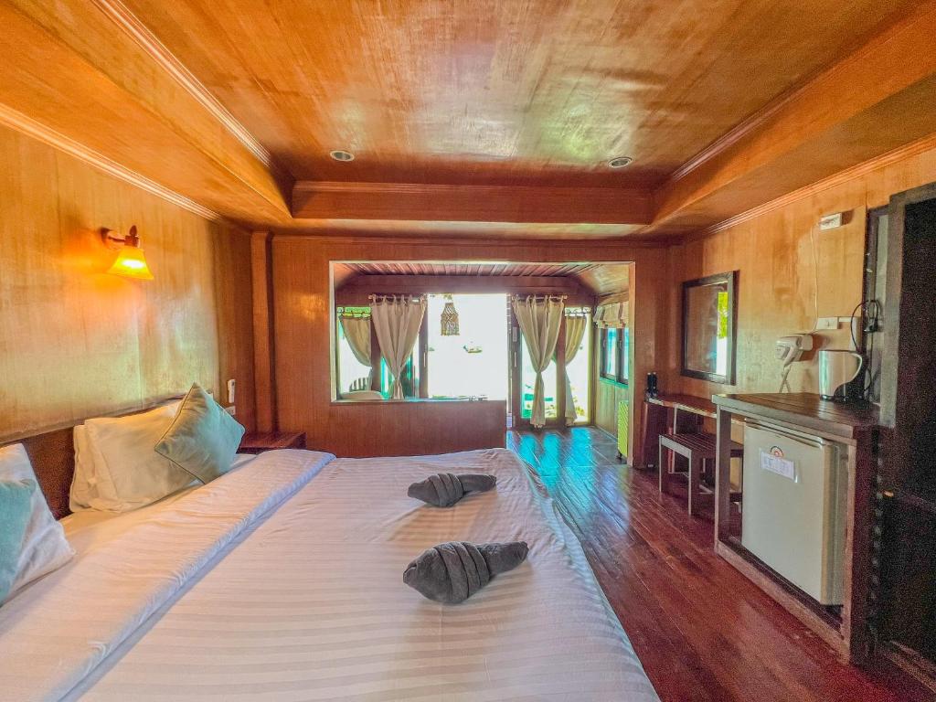 a bedroom with a bed with two pillows on it at Lipe Power Beach Resort in Ko Lipe