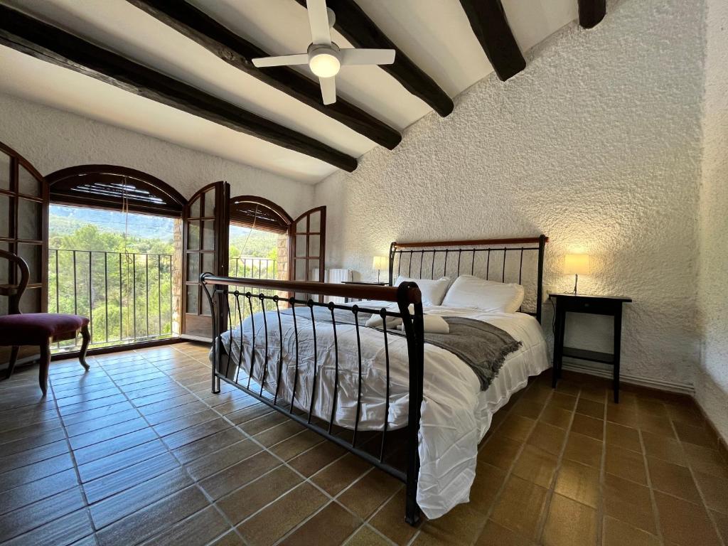 a bedroom with a bed and a large window at Cal Poldo in Marganell
