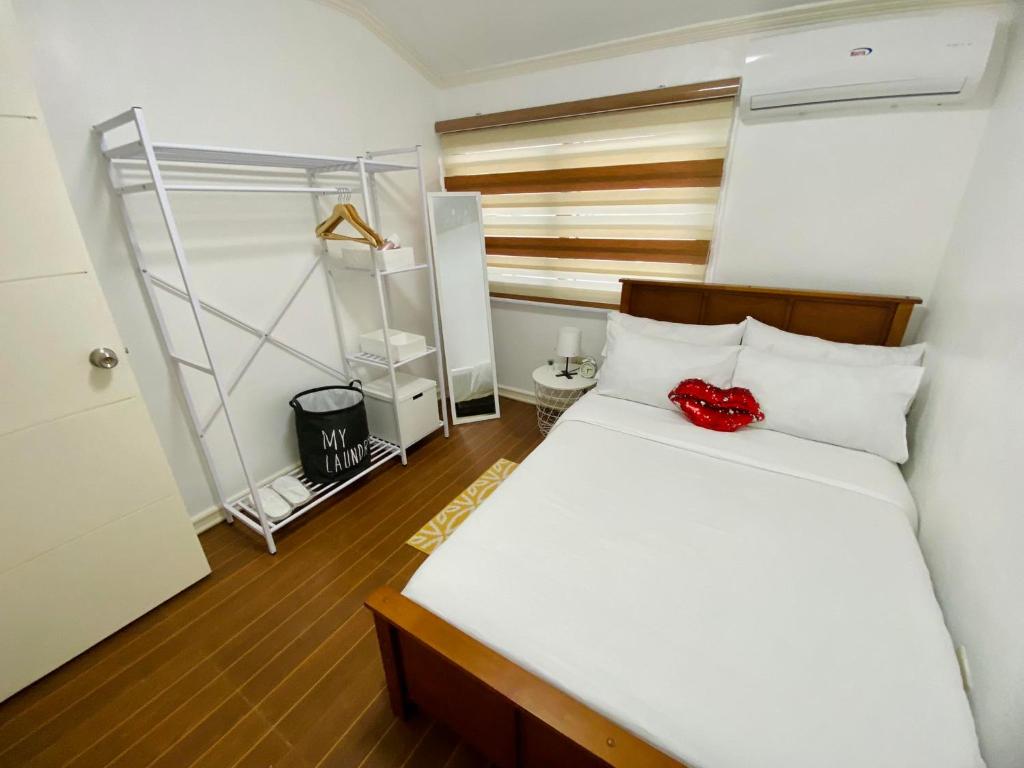 Gillera Staycation in Lipa في ليبا: غرفة نوم بسرير عليها وردة حمراء