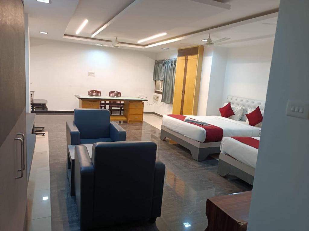 Habitación de hotel con 2 camas, mesa y sillas en HOTEL BLUE MOON, en Nellore